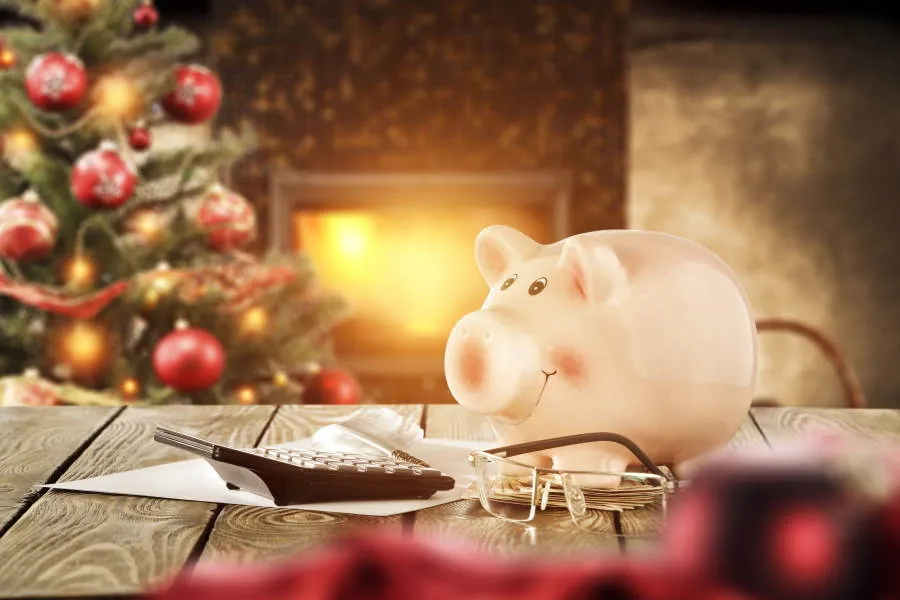 Piggy bank in front of a Christmas tree